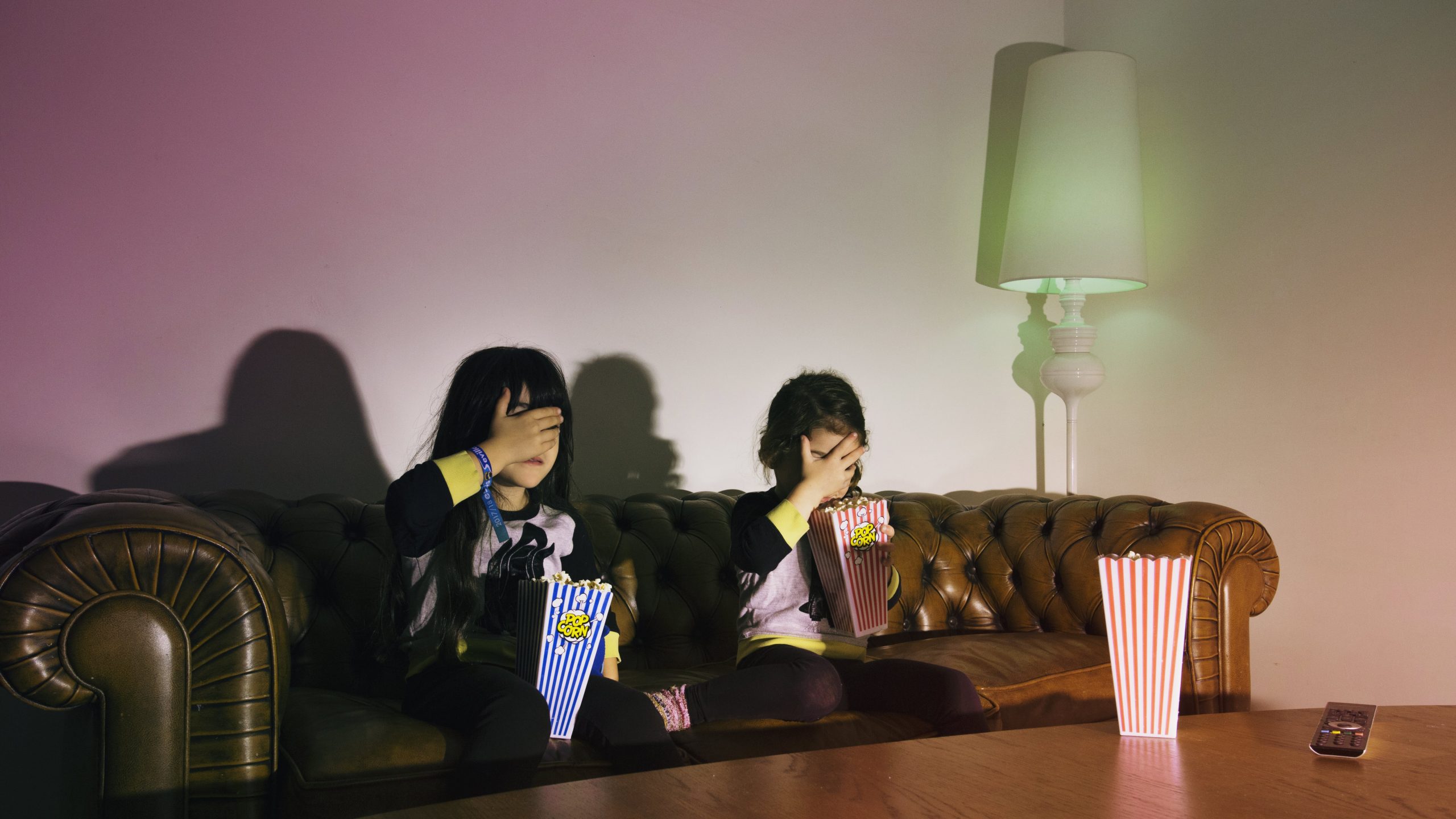 scared-girls-with-popcorn-watching-tv-min